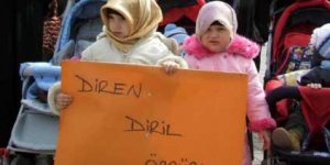 2 yaşındaki kızın başına türban, eline pankart